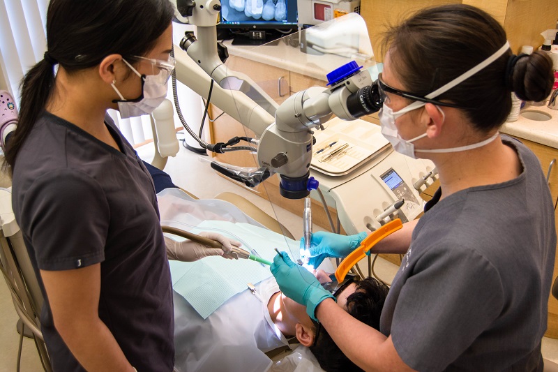 Dental team assisting with patient treatment